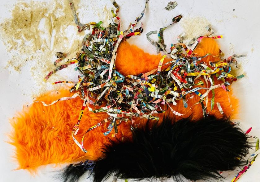 Fühlbild aus verschiedenen Materialien, abstrakt mit orange und schwarz
